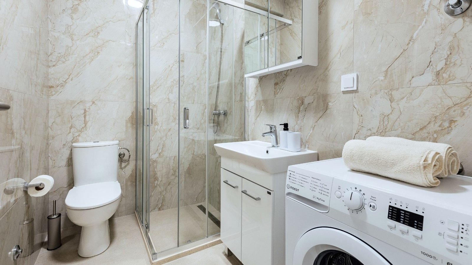 Bathroom with walk-in shower in modern one-bedroom apartment.