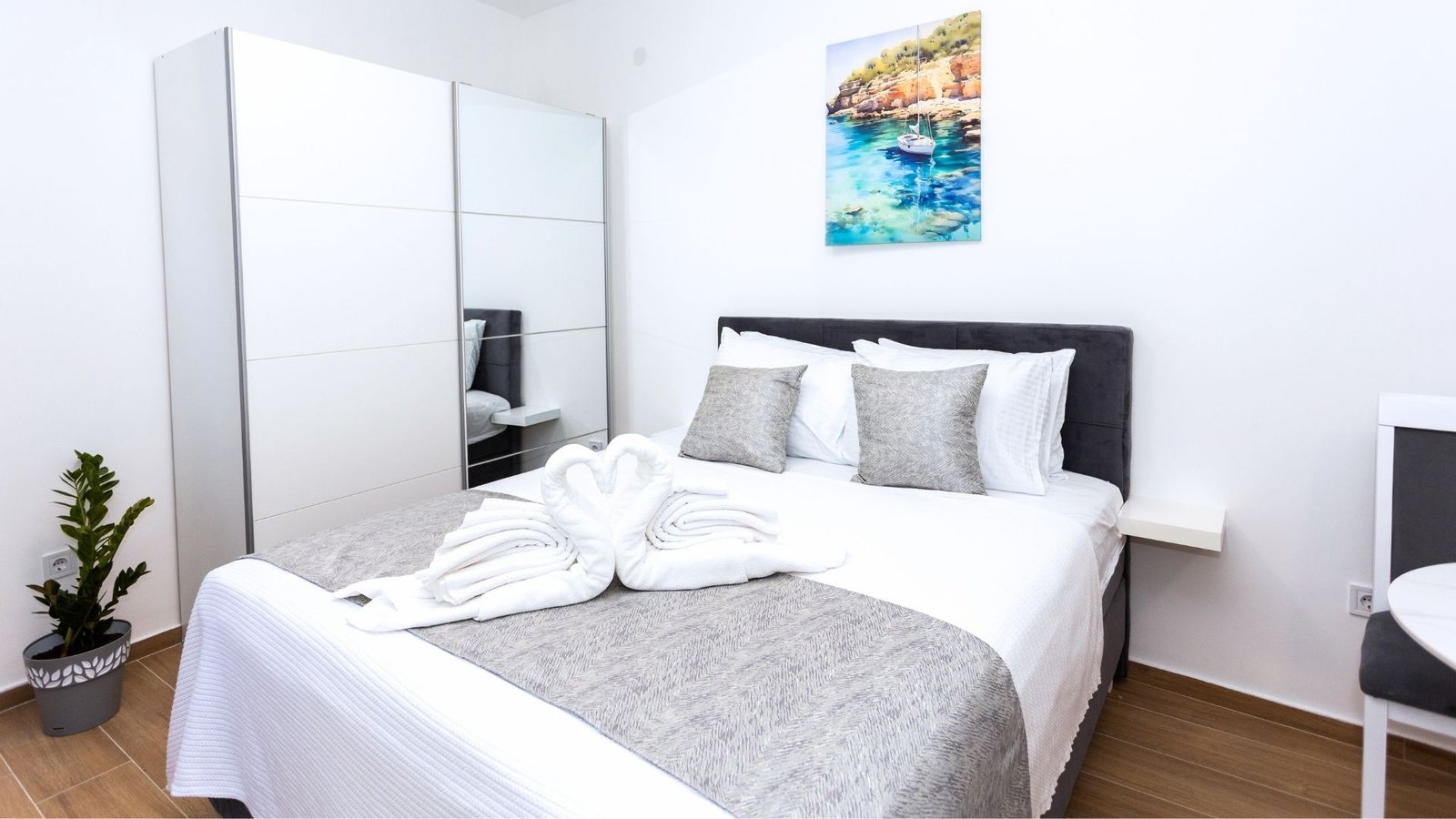 Double bed with white linen and painting in studio apartment Herceg Novi